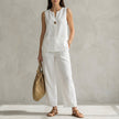 White FJØRNA two-piece women's co-ord set with V-neck top and matching pants featuring pockets, stylish and comfortable.