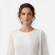 Women's white chiffon pleated maxi dress by FJØRNA, flowing design with pleats, suitable for wedding guests.