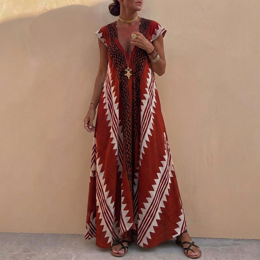 Wine red FJØRNA women's maxi dress with geometric V-neck design, flowing fabric and elegant silhouette.