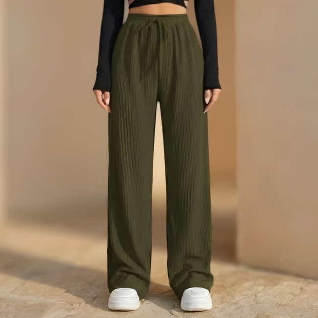 Women’s wide-leg pleated trousers with elastic waist by FJØRNA, showcasing relaxed fit and stylish design.