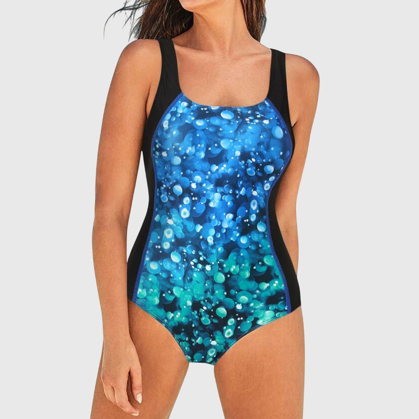 Women's FJØRNA square neck swimsuit with multi-pattern print, showcasing stylish design and athletic fit.