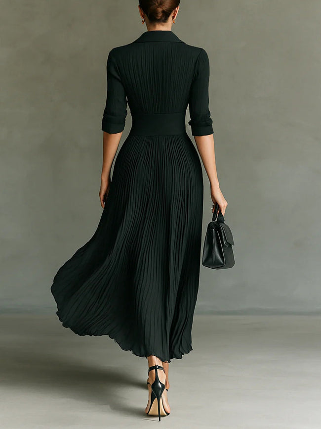 FJØRNA elegant women's maxi dress with V-neck and pleated design, featuring a flowing silhouette and sophisticated style.