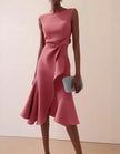 Pink FJØRNA midi dress for women with round neck, sleeveless design, ruffle and bow details, perfect for elegant daytime wear.