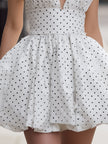 FJØRNA vintage white halter polka dot bubble mini dress for women, showing the playful, retro-inspired style with a fitted bodice and flared skirt.