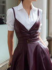 White shirt dress with wine-red leather suspender set by FJØRNA, showcasing a stylish combination of dress and suspenders.