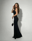 Black satin bodycon maxi dress by FJØRNA, featuring a sleek, form-fitting design with elegant stretch fabric for glamorous evening wear.