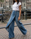 FJØRNA women's lightweight summer trousers with high waist, wide leg, button front, and breathable fabric in a soft color.