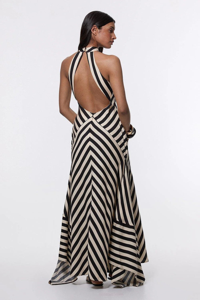 FJØRNA Mono Fluid Stripe Maxi Halter Dress in white, flowing fabric with halter neckline, perfect for elegant summer wear.