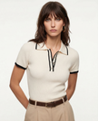 Black cotton polo top for women by FJØRNA, stylish and comfortable women's polo shirt with a classic collar and short sleeves.