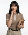 Black cotton polo top for women by FJØRNA, casual short-sleeve polo shirt with a classic collar, suitable for everyday wear.