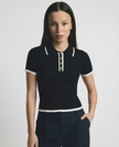 Black cotton polo top for women by FJØRNA, featuring a classic polo shirt design and a comfortable fit.