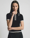 Black cotton polo top for women by FJØRNA, featuring a classic polo shirt design for ladies.