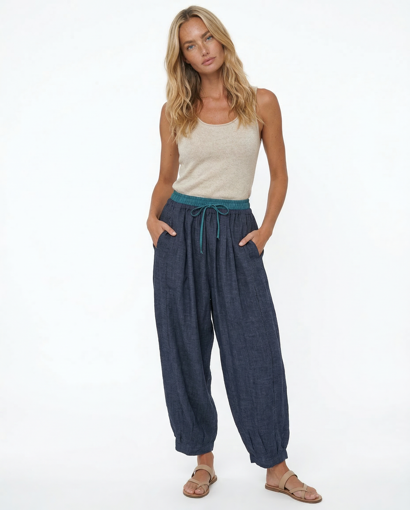 FJØRNA women's linen tapered trousers, stylish and comfortable pants, shown in a natural beige color with a relaxed fit.
