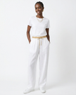 FJØRNA women's linen tapered trousers, light and breathable pants with a relaxed fit, shown in a natural beige color.