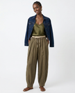 FJØRNA women's linen tapered trousers, stylish and comfortable pants with a relaxed fit, shown in a natural fabric and color.