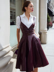 White shirt dress with wine-red leather suspenders from FJØRNA, stylish leather dress perfect for elegant daytime wear.