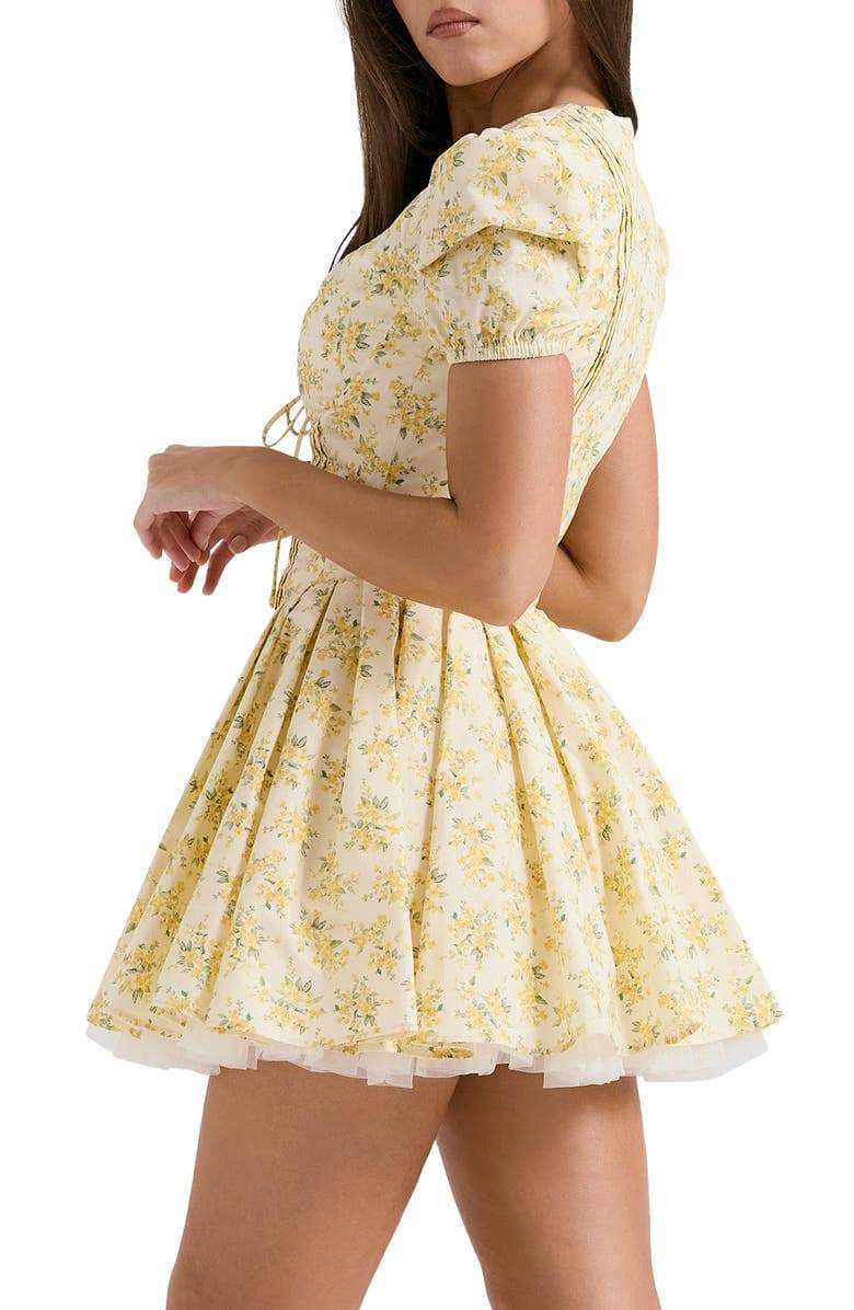 FJØRNA Emily Floral V-neck Corset Mini Dress in white with yellow floral pattern, sleeveless design, fitted silhouette, and mini length.
