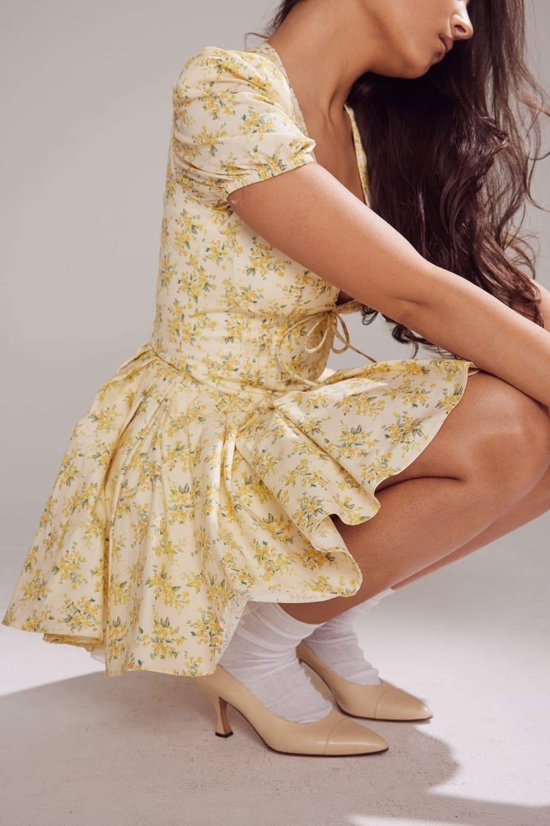 FJØRNA Emily floral V-neck corset mini dress in white, featuring a fitted bodice and floral pattern, perfect for summer wear.