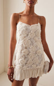 White rosette georgette frilled mini dress by FJØRNA, perfect for wedding guest attire, featuring delicate ruffles and floral details.