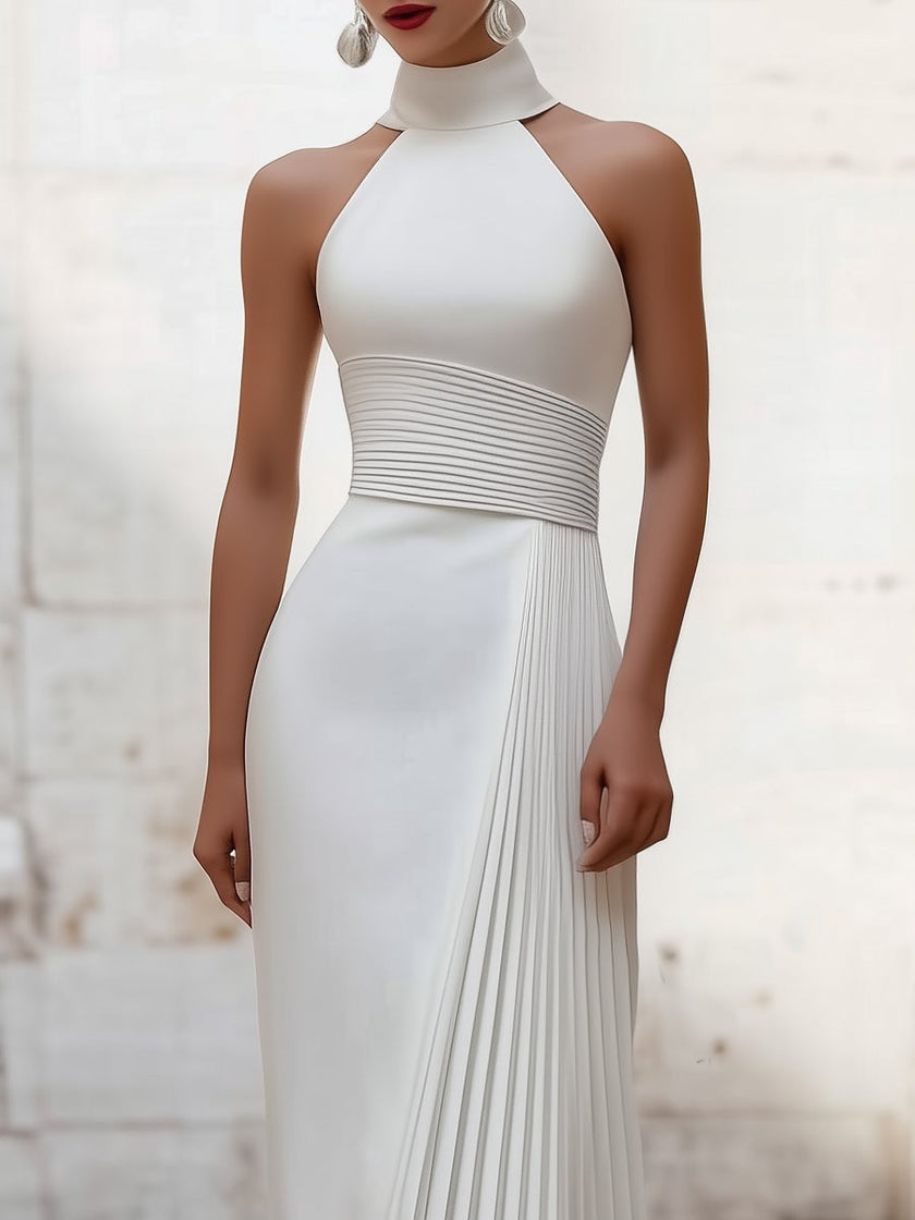 White satin pleated halter evening gown by FJØRNA with elegant design, showcasing the flowing pleats and sophisticated halter neckline.