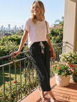 FJØRNA women's lightweight summer trousers with drawstring waist, breathable casual pants for warm weather, in a relaxed fit.