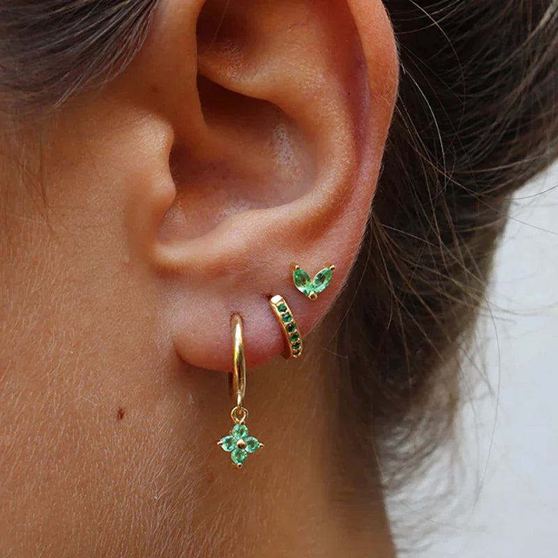 FJØRNA unisex minimalist piercing set with gold and green stainless steel hoops and studs, stylish accessories for women.