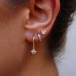 Unisex minimalist piercing set by FJØRNA with gold and green-stone hoops and studs, featuring stainless steel jewelry for women.