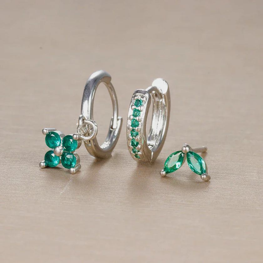 Unisex minimalist piercing set by FJØRNA with gold and green stainless steel hoops and studs, designed for effortless all-day wear.