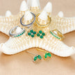 Unisex minimalist piercing set by FJØRNA with gold and green stainless steel hoops and studs for women.