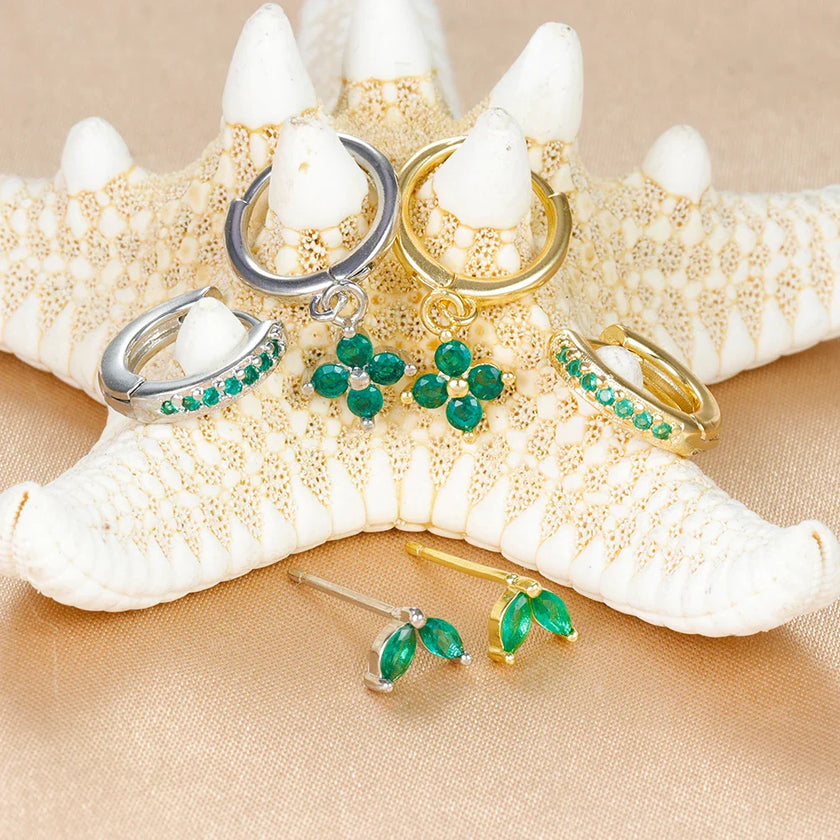 Unisex minimalist piercing set by FJØRNA with gold and green stainless steel hoops and studs for women.