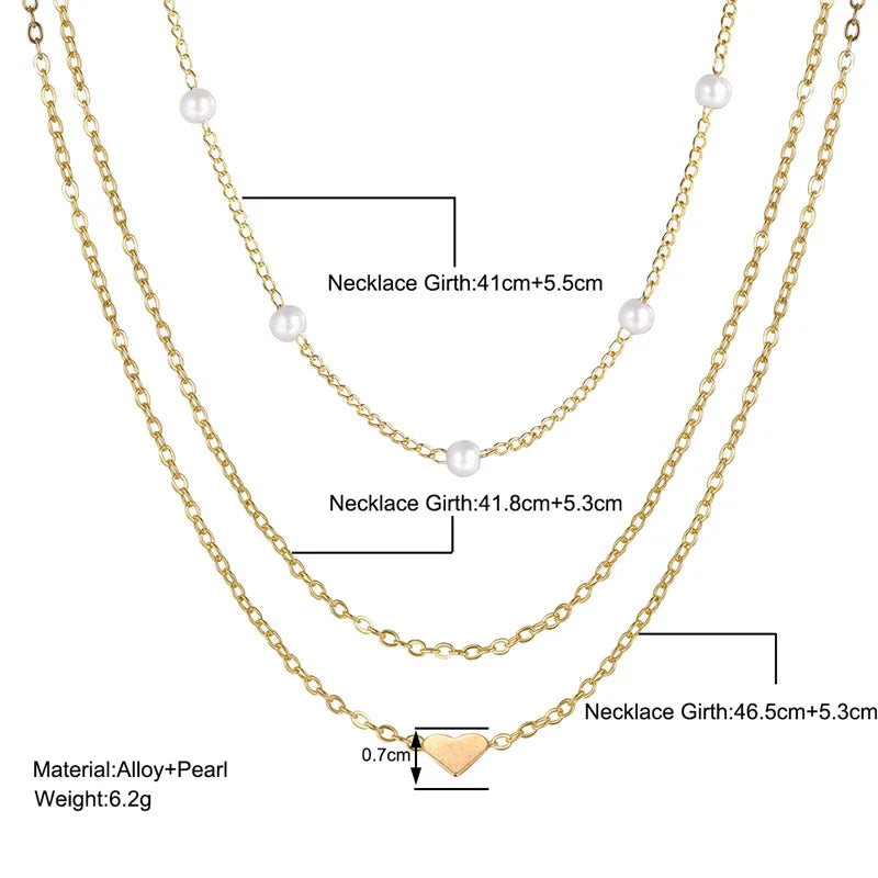 FJØRNA gold 3-layer pearl pendant necklace set for women with heart and cross charms, layered accessory jewelry.