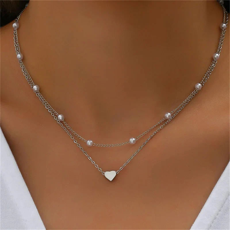 Gold 3-layer pearl pendant necklace set for women by FJØRNA, featuring layered gold and silver necklaces with heart and cross pendants.