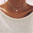 FJØRNA gold 3-layer pearl pendant necklace set for women with heart and cross charms, layered design, gold and silver accents.