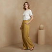 White cotton linen wide-leg women's trousers with high waist, pockets, and relaxed fit, styled on a model.