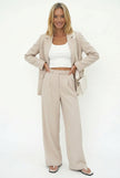 White wide-leg high-waist trousers for women by FJØRNA, shown styled with a casual outfit on a model.