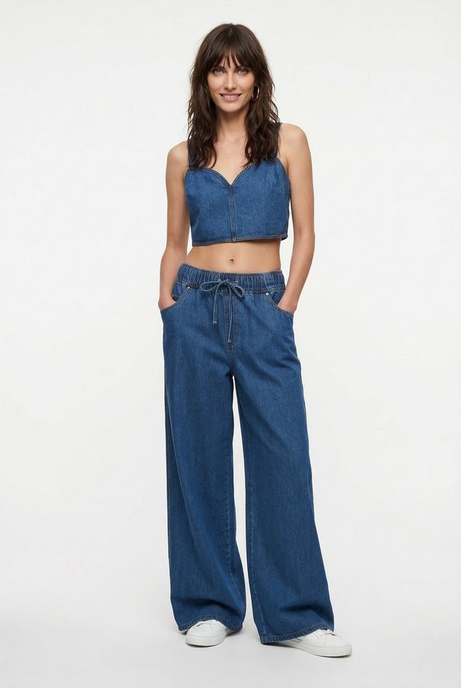 Blue denim wide-leg drawstring jeans for women by FJØRNA, featuring relaxed fit and casual style.