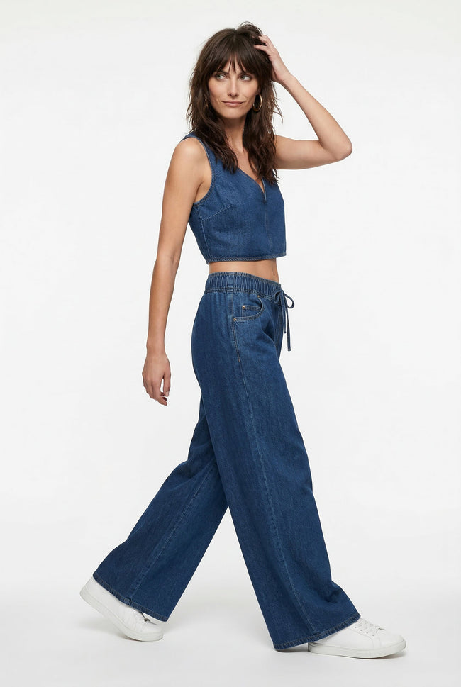 Blue denim wide-leg drawstring pants for women by FJØRNA, relaxed fit, casual style, shown on a model.