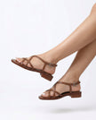 FJØRNA Italian leather cushioned brown sandals for women worn on female feet with white-painted toenails, studio shot on white background.