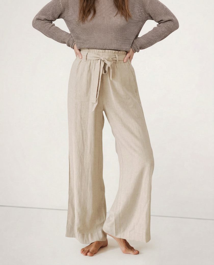 FJØRNA women's linen wide-leg trousers, loose pull-on pants with soft fabric, shown hanging to highlight relaxed fit and quality.