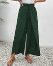 Green FJØRNA women's lightweight summer trousers with wide leg design and breathable fabric, perfect for warm weather wear.