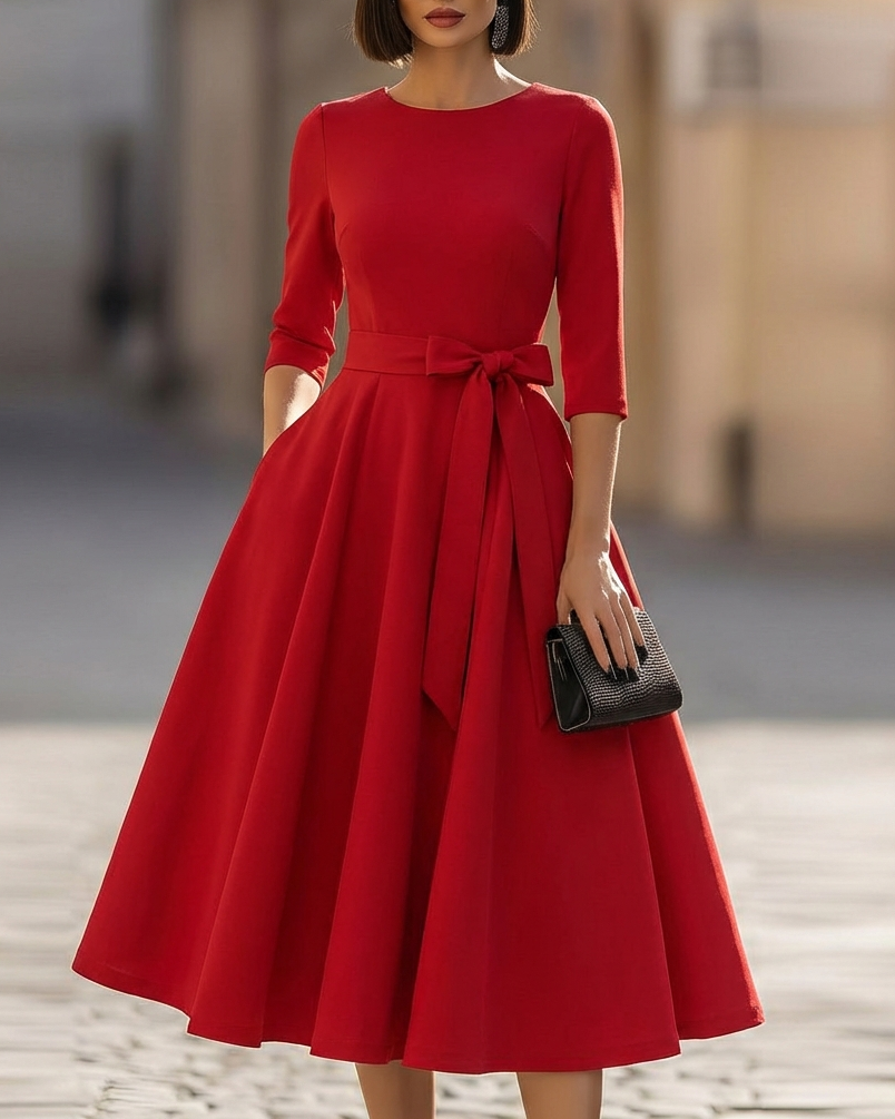 FJØRNA crew-neck A-line midi dress, stylish wedding guest dress in soft fabric, shown on a hanger with a neutral background.