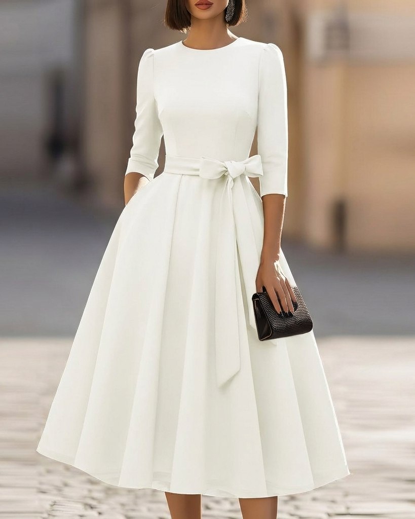 FJØRNA crew-neck A-line midi dress, elegant wedding guest dress in soft fabric, shown on a hanger with a neutral background.