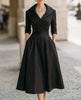 Black satin trench-collar wrap midi dress by FJØRNA, featuring a sleek design for elegant women’s occasion wear.
