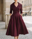 Black satin trench-collar wrap midi dress by FJØRNA, featuring a sleek, elegant design perfect for women.