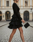 FJØRNA high-neck long-sleeve tiered ruffle mini dress for cocktail occasions, featuring a flowy, layered design.