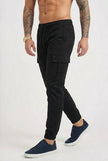 Men's black cargo jogger trousers by FJØRNA with multiple pockets and tapered fit, shown on a model.