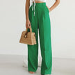 Lightweight high waist wide-leg pleated summer trousers for women by FJØRNA, shown in a natural pose.
