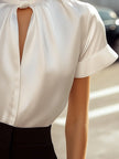 White satin high-neck keyhole blouse for women by FJØRNA, featuring a stylish high neckline and elegant keyhole detail.