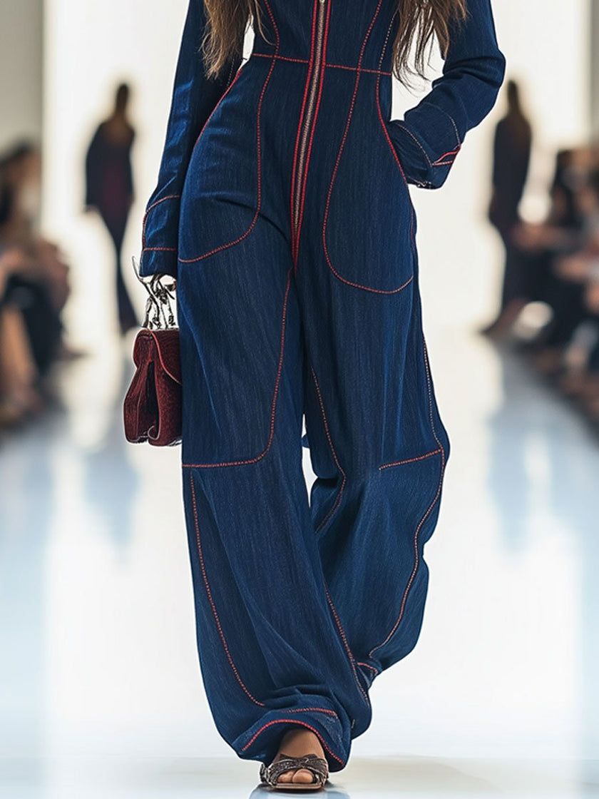 Dark blue FJØRNA women's denim jumpsuit with topstitching, wide-leg pants, and long sleeves, styled with a casual fit.