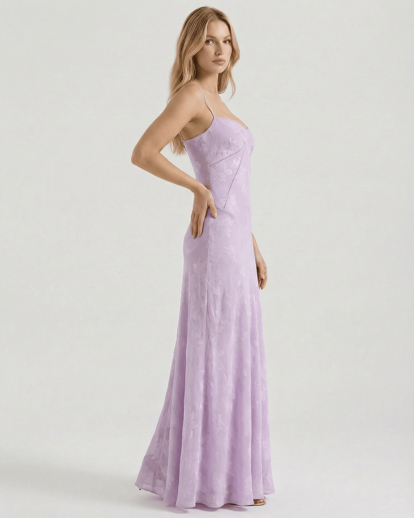 Lavender lace spaghetti-strap maxi dress by FJØRNA with floral print, sheer fabric, and lace-up back, ideal for wedding guests.